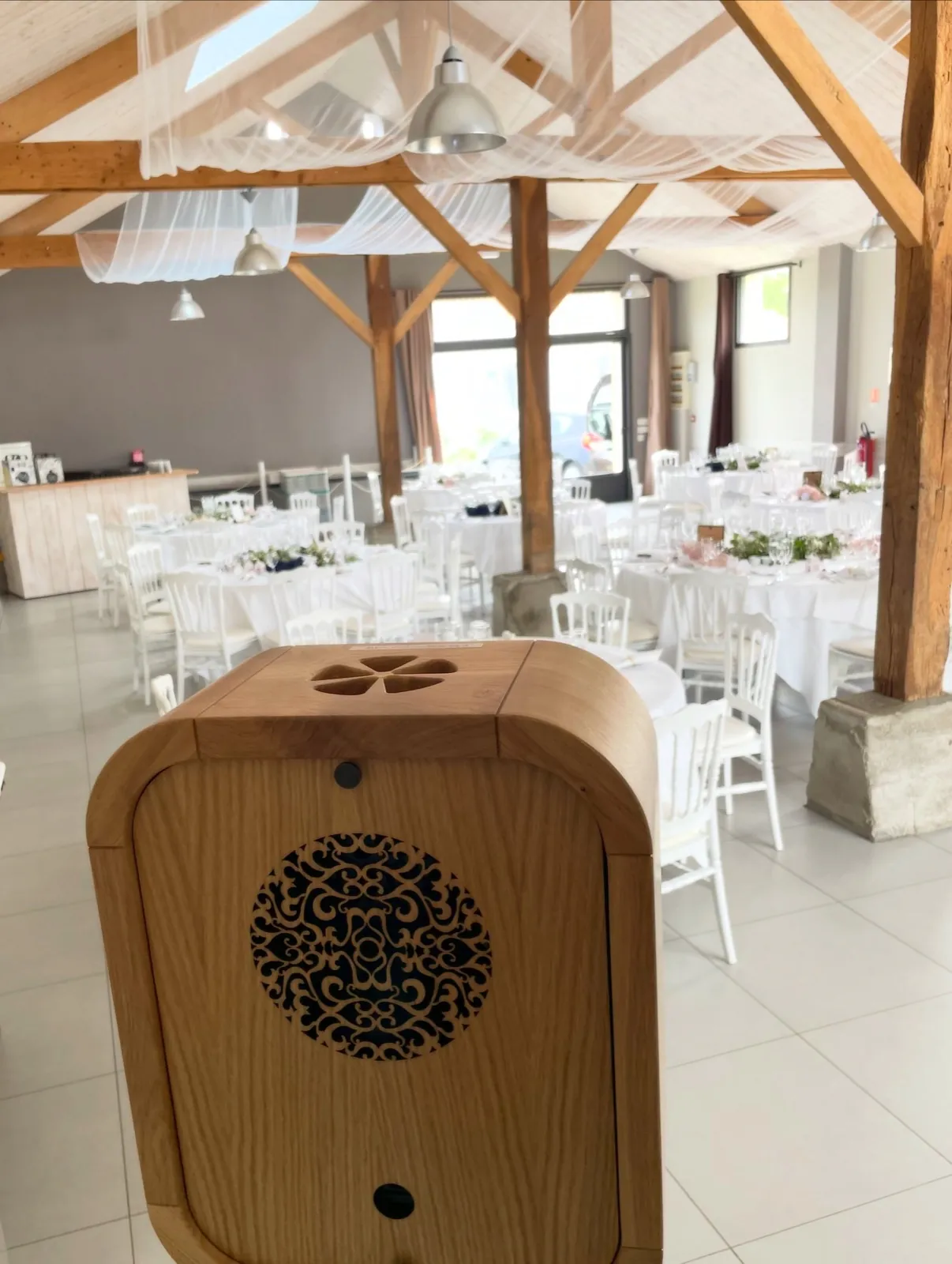 Photobooth en bois installé dans une salle de réception de mariage